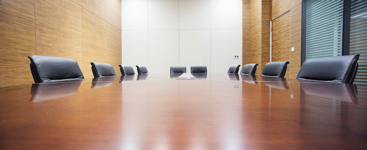 Law firm office with empty chairs surrounding conference table.
